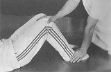 膝窩に圧痛のある足の上に操者は軽く手を置いて操体整体を始める